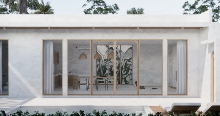 Modern white residential building with large glass door and window panels, minimalist design with tropical landscaping.